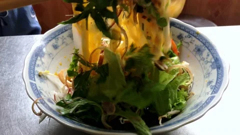 Adding vegetables and mixing a bowl of Mi Quang - Vietnamese rice noodle with Stock Footage 142343004