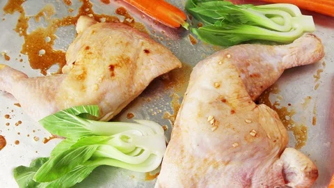 Adding vegetables to chicken quarters sheet pan meal Stock Footage 91448901