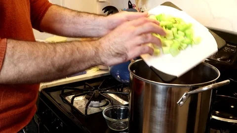 Adding Vegetables to a Pot on the Stove, 4K Video stock 121483311