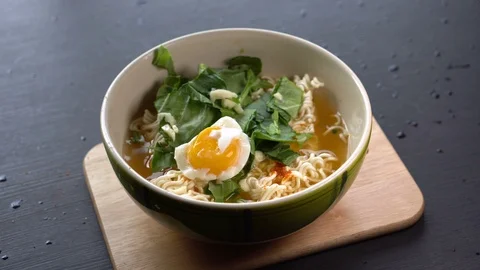 Adding Veggies and egg to Boring Instant Ramen Stock Footage 105846198