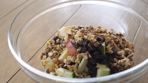 Adding Walnuts to tropical salad in slow motion Stock Footage 85130347