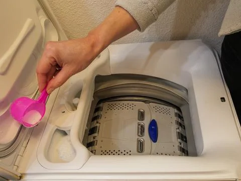 Adding washing powder detergent into a top loading washing machine Stock Photos