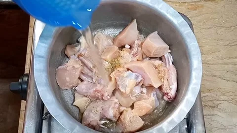Adding Water to Chicken for Boiling and Tenderizing, Start of Cooking Process, Stock Footage 323351881