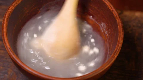 Adding water to flour for mixing Stock Footage 248356384