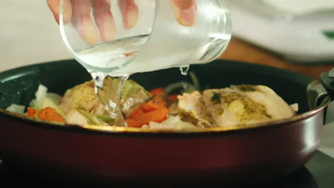 Adding water to frying chicken Stock Footage 165503311