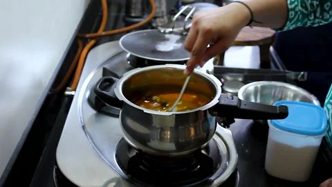 Adding Water to Khichdi in Pressure Cooker Indian Home Cooking Close Up Видео 336441006
