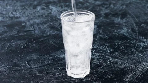 Adding water or soda to a full glass with ice Stock Footage 201129569