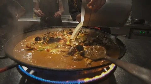 Adding water to paella to boil the rice Stock Footage 100394392