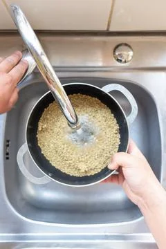 Adding water to a pot with lentils Stock Photos