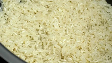 Adding water to rice-cooker containing white rice ready for cooking, includes Stock Footage 62760497