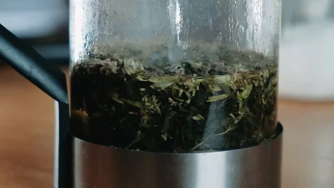 Adding water to tea leaves in a Glass. Matcha Organic Green Tea. Matcha Tea Stock Footage 129732087