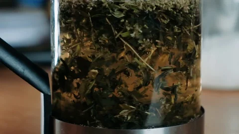 Adding water to tea leaves in a Glass. Matcha Organic Green Tea. Matcha Tea Stock Footage 129732199