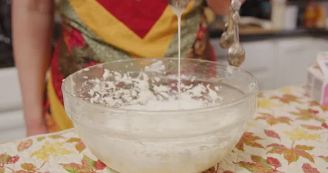 Adding whipping cream into mix in mixing bowl Video stock 249368210