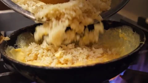 Adding White Rice to Scrambled Eggs in a Hot Frying Pan Video stock 347688173