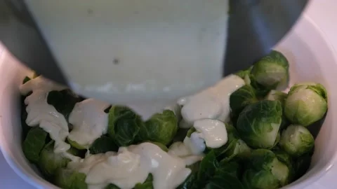 Adding white sauce to Brussel sprouts Stock Footage 219518507