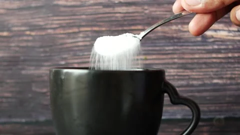 Adding white sugar into black coffee cup using small silver spoon in slow m.. 스톡 동영상 332777834