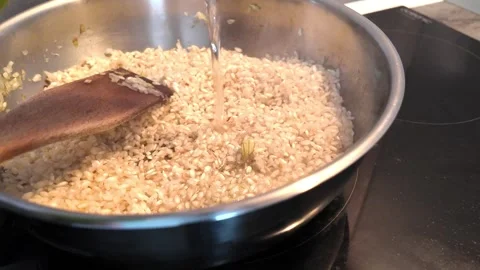 Adding white wine during homemade risotto preparation 스톡 동영상 345082908