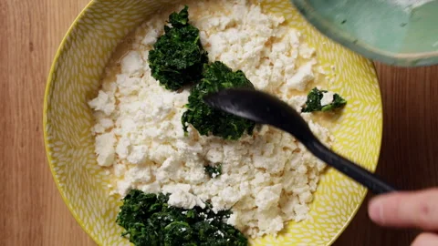 Adding Wilted Spinach To Feta Cheese Bowl Top View Stock Footage 337246884
