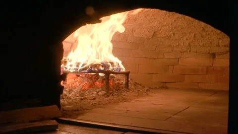 Adding wood to the fire in pizza oven on wood Stock-Footage 123649605