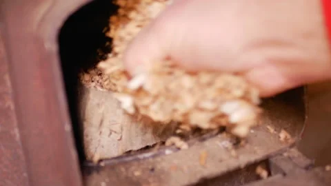 Adding wood shavings, chips and sawdust into the potbelly stove Stock Footage 170829821