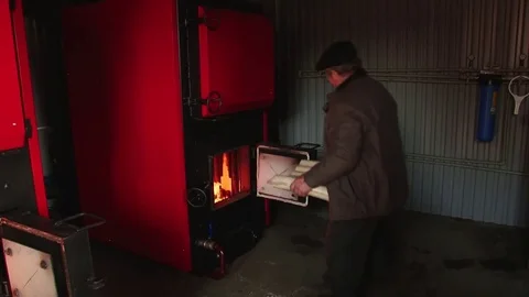 Adding wood to a stove Stock Footage 70517396