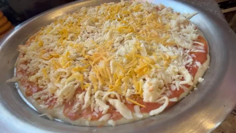 Adding Yellow Cheese Topping Over Shredded Cheese on Dough Stock Footage 344786404