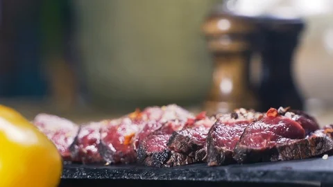Adds salt and pepper to the dish, Caucasian kitchen tasty beefsteak Stock Footage 107740418