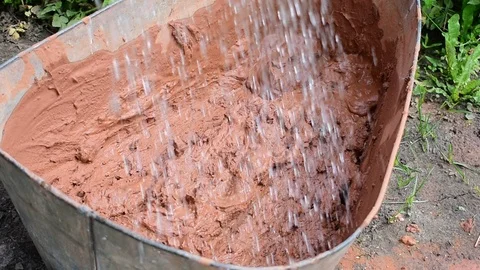 Adds water to clay Stock Footage 117472435