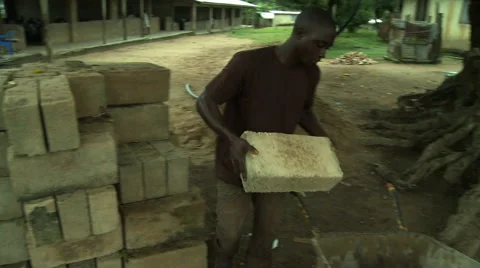 ADEISO MAN LOADS A BLOCK INTO WHEELBARROW Stock Footage 57982702