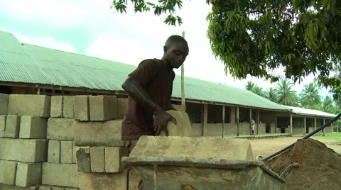 ADEISO MAN LOADS BLOCK INTO WHEELBARROW Stock Footage 57982725