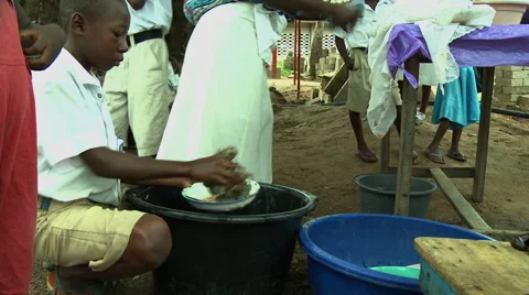ADEISO SCHOOL LUNCH: BOY STUDENT WASHES DISHES 2 Stock Footage 58067586