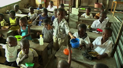 ADEISO SCHOOL LUNCH: WIDE PAN OF YOUNG STUDENTS EATING IN A CLASSROOM Stock Footage 58068537