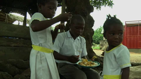 ADEISO SCHOOL LUNCH: YOUNG BOY STUDENT SHARES FOOD WITH YOUNG GIRL STUDENTS Stock Footage 58067582