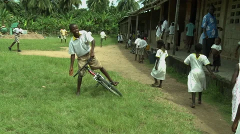 ADEISO STUDENTS WALK INTO SCHOOL (BOY STUDENT MOUNTS BIKE) Stock Footage 58069223