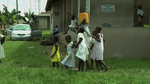 ADEISO STUDENTS WALK TOWARDS SCHOOL (BOY WITH WATER CONTAINER ON HEAD) Stock Footage 58069528