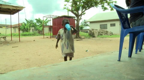 ADEISO YOUNG STUDENT DRINKS WATER FROM CUP (CROSSES INTO CLASSROOM) Stock Footage 58069622