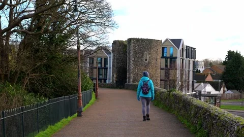 Adele walking along Canterbury city walls Stock Footage 321469504