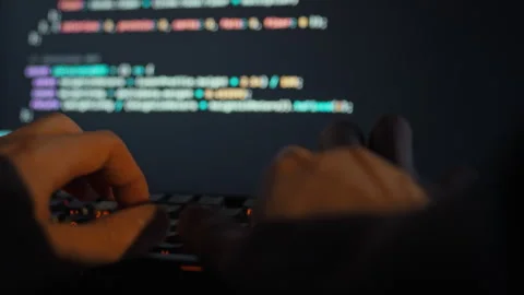 An adept programmer intensely codes on the keyboard refining a complex machi Video stock 335462415