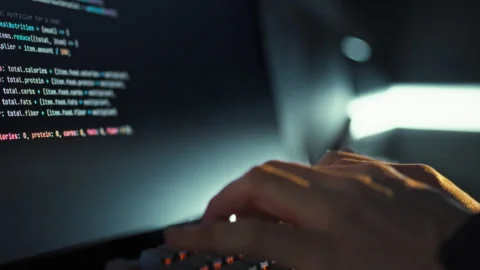An adept programmer swiftly enters intricate code on the keyboard instantly 動画素材 336570760