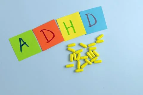 ADHD abbreviation on multi-colored paper and a bunch of pills. Attention Deficit Stock Photos