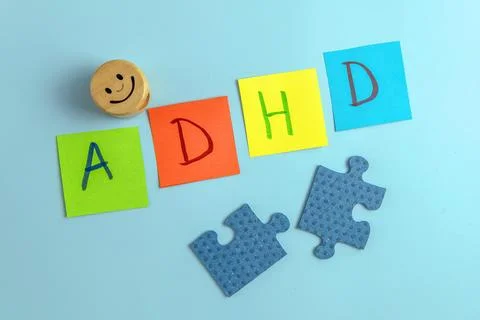ADHD abbreviation on multi-colored paper and puzzle pieces with the smiley Stock Photos