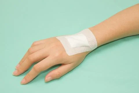 Adhesive healing plaster on hand Stock Photos