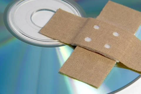 Adhesive plaster and CD ROM detail data rescue theme with band-aid and CD-... Stock Photos