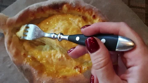 Adjarian Khachapuri. Fork stirs hot cheese inside pita bread 스톡 동영상 129617455