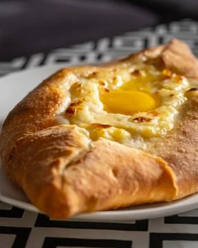 Adjarian khachapuri with fresh egg on table, Caucasian Georgian cuisine Stock Photos