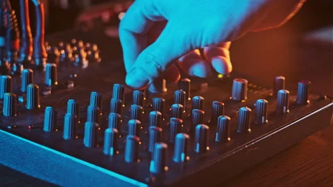 Adjust Volume Controls on the Audio Mixer in Neon Light Close-Up Stock Footage 263677718