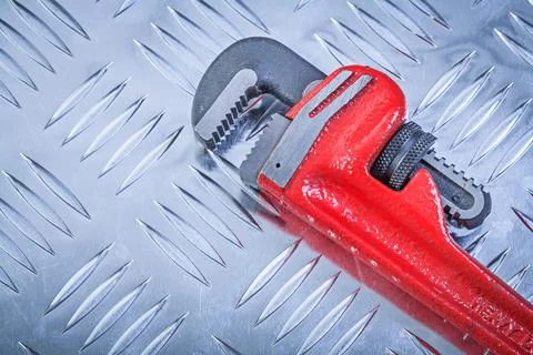 Adjustable open-end spanner on ribbed metal plate Design concept Stock Photos