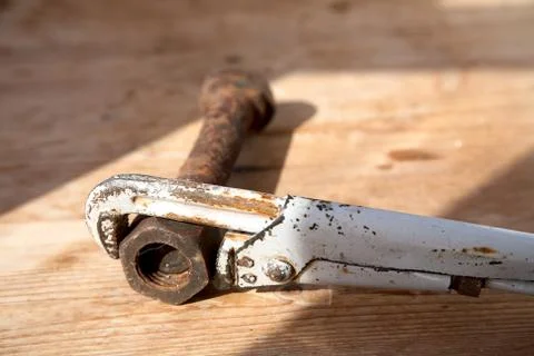 Adjustable spanner and rusty bolt with a nut on  table Stock Photos
