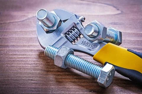 Adjustable spanner Steel threaded bolts and nuts on wooden plates Design concept Stock Photos