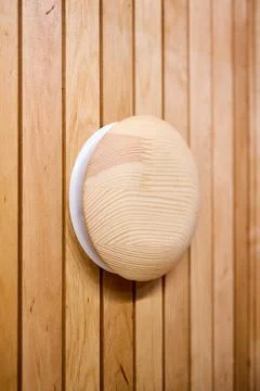 Adjustable wooden diffuser installed on vertical sauna wall panels. Round val Stock Photos